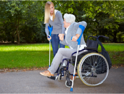 a lady assisting an old woman to walk
