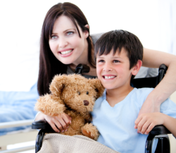 a child sitting in a wheelchair and a lady smiling